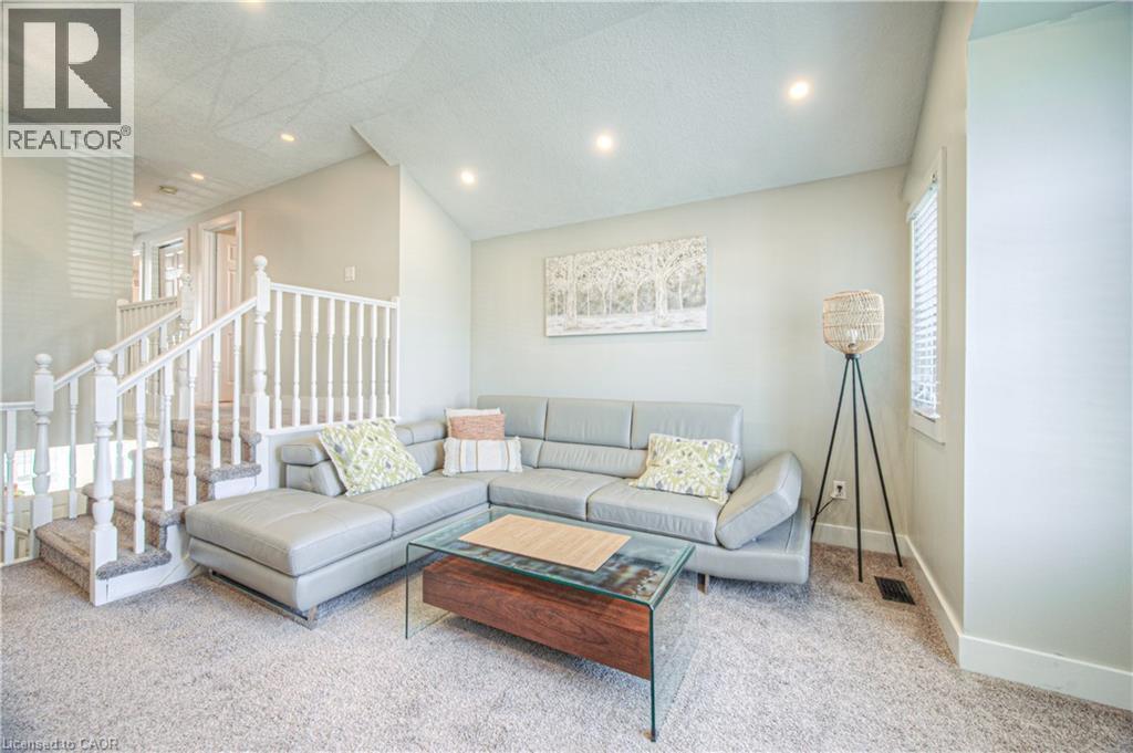 Carpeted living area with lofted ceiling, recessed lighting, and stairway - 220 Sienna Crescent, Kitchener, ON - Indoor Photo Showing Living Room