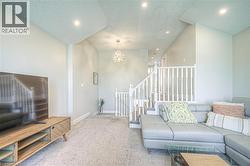 Carpeted living area with a textured ceiling, recessed lighting, and a chandelier -