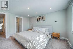 Bedroom with light carpet, a textured ceiling, and recessed lighting -