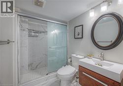 Full bath featuring a marble finish shower, vanity, and marble finish floors -