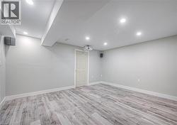 Finished basement with light wood-style floors and recessed lighting -