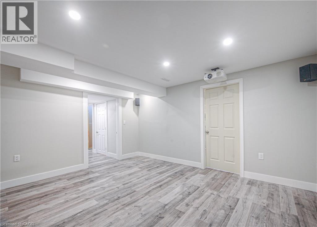 Finished basement featuring light wood-type flooring and recessed lighting - 220 Sienna Crescent, Kitchener, ON - Indoor