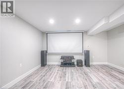 Cinema with light wood finished floors and recessed lighting -