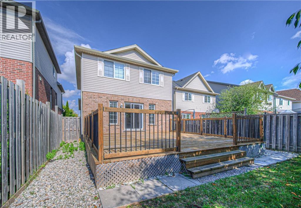 Rear view of property featuring a fenced backyard, a deck, a residential view, and brick siding - 220 Sienna Crescent, Kitchener, ON - Outdoor With Deck Patio Veranda With Exterior