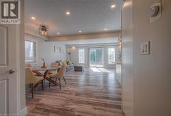 Dining area with a textured ceiling, light wood finished floors, recessed lighting, and plenty of natural light -