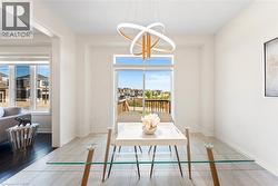 Dining space featuring healthy amount of natural light, tile patterned floors, and a chandelier -