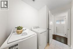 Washroom featuring light tile patterned flooring and independent washer and dryer -