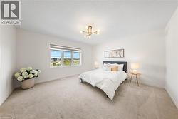 Bedroom featuring light colored carpet and a chandelier -