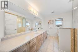 Bathroom with light tile patterned flooring, vanity, a bath, and a walk in shower -