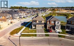 Aerial perspective of suburban area featuring a nearby body of water -