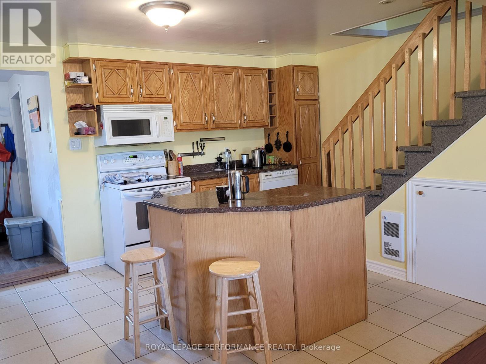 Kitchen with stairs leading upstairs. - 975 Queen Street, Champlain, ON - Indoor Photo Showing Kitchen