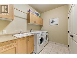 Laundry room on the main level with cabinets and sink -