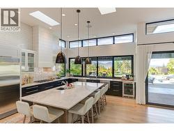 A 6 person sit up island with marble counters, pending lighting and sink -