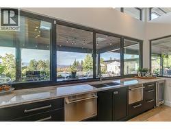A wall of sliding windows above the dual sink open to bring the outdoor in. As well as two seperate dishwashers -