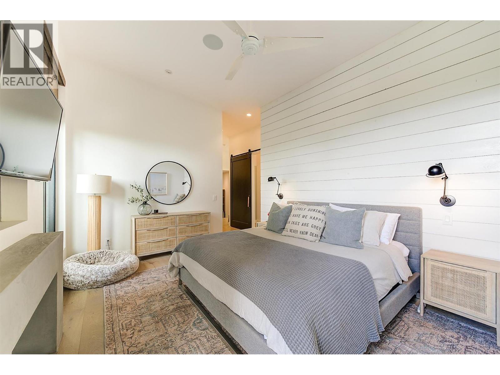 The king size bedroom offers shiplap wall detail and wall sconces - 763 Barnaby Road, Kelowna, BC - Indoor Photo Showing Bedroom