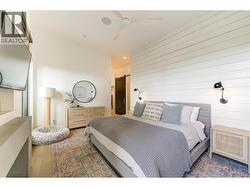 The king size bedroom offers shiplap wall detail and wall sconces -