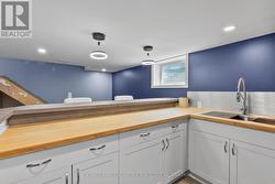 Basement bar are with sink and full sized fridge. -