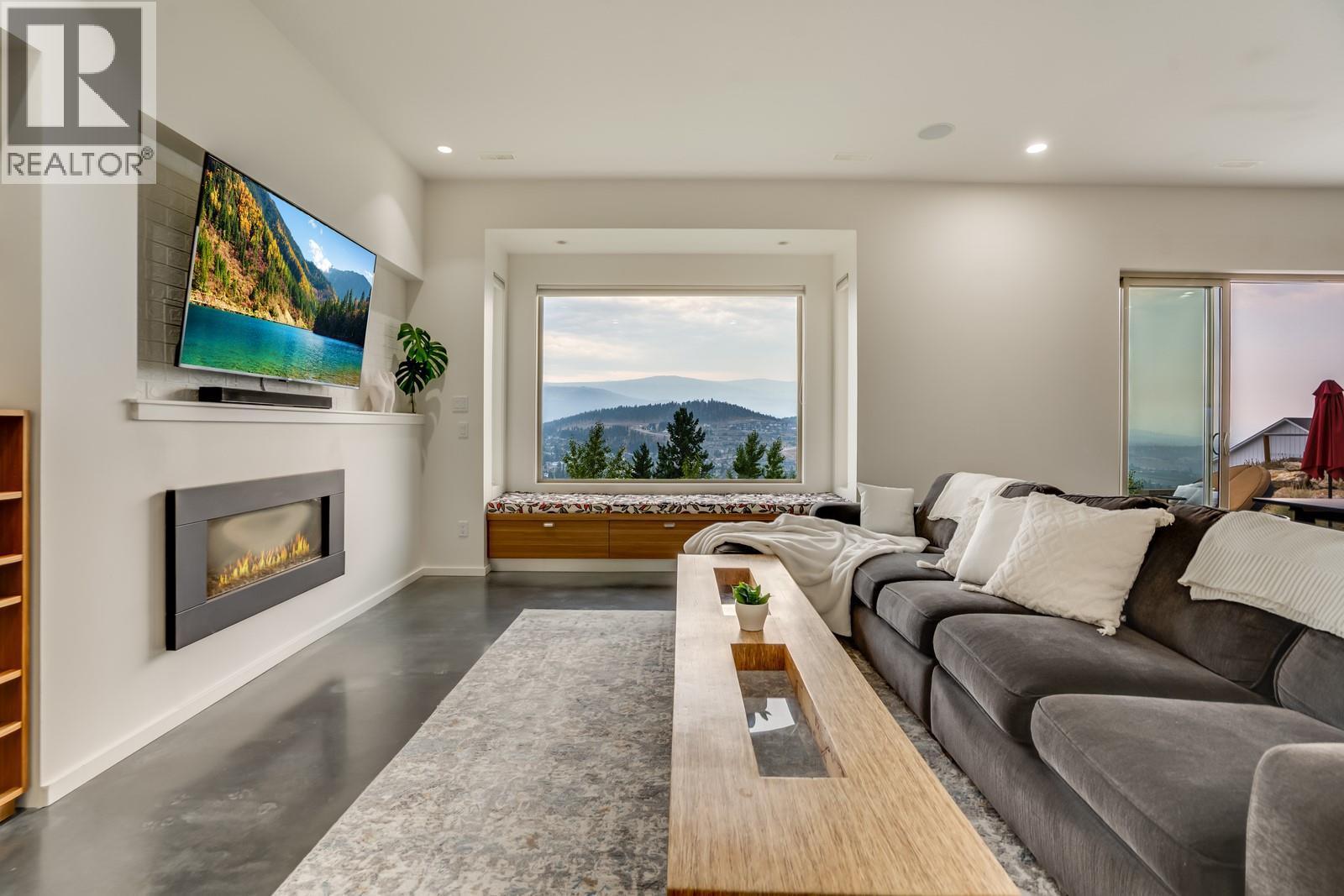 Heated concrete polished floors throughout - 1040 Henderson Drive, Kelowna, BC - Indoor Photo Showing Living Room With Fireplace