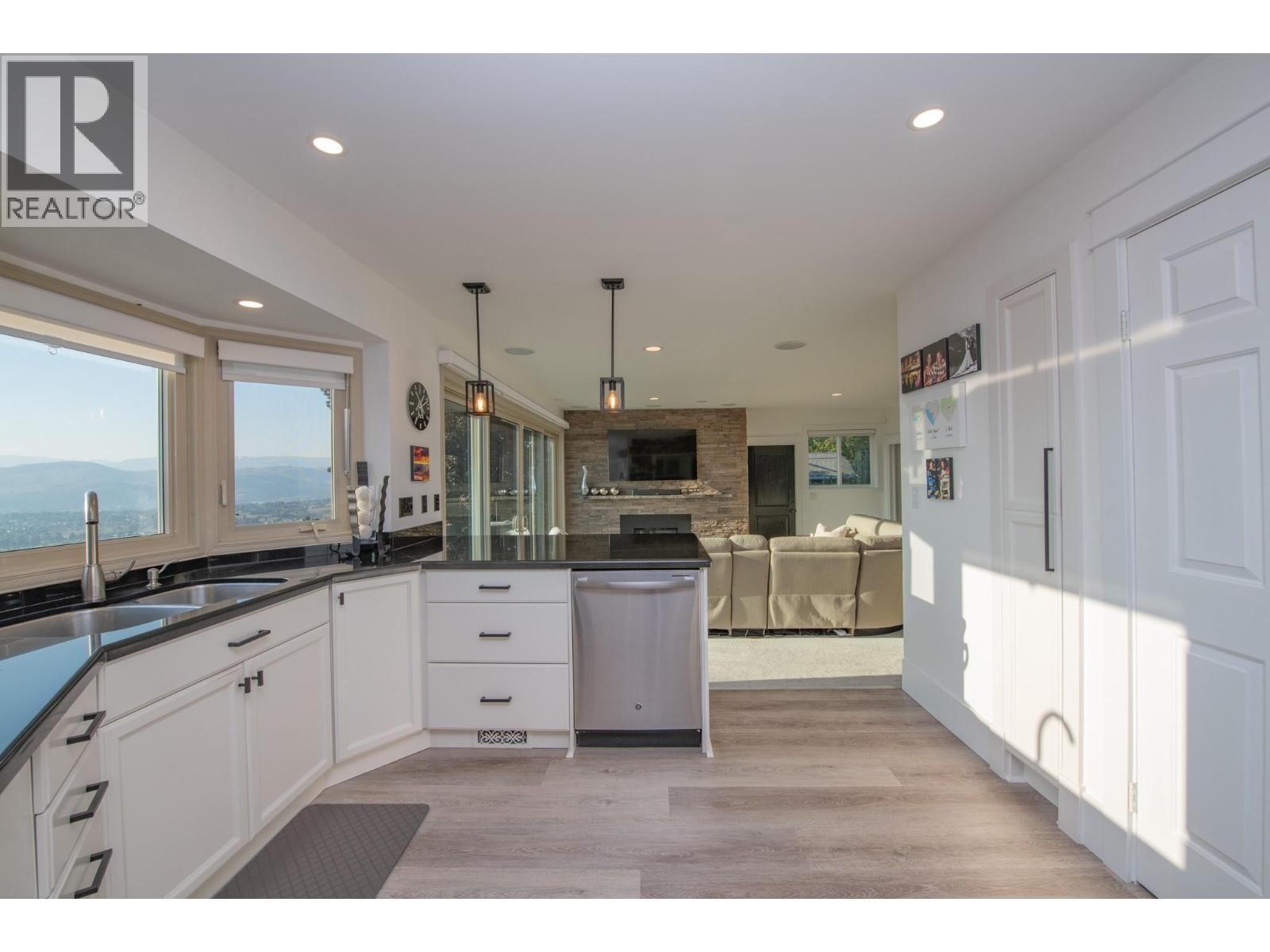 Pantry and door to downstairs on the right - 702 Cypress Drive, Coldstream, BC - Indoor Photo Showing Kitchen With Double Sink