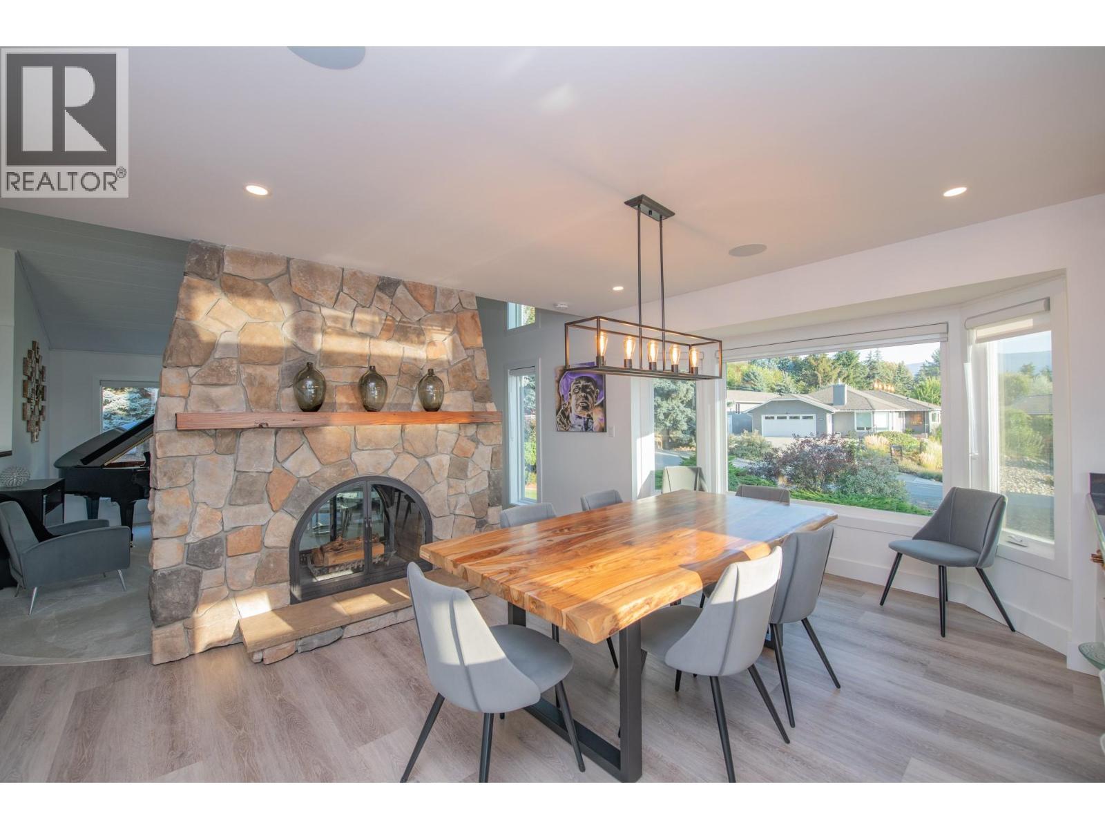 Dining room with see through fireplace - 702 Cypress Drive, Coldstream, BC - Indoor Photo Showing Other Room With Fireplace