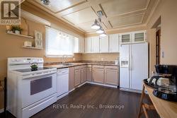 The kitchen has a beautiful wood panel ceiling. -