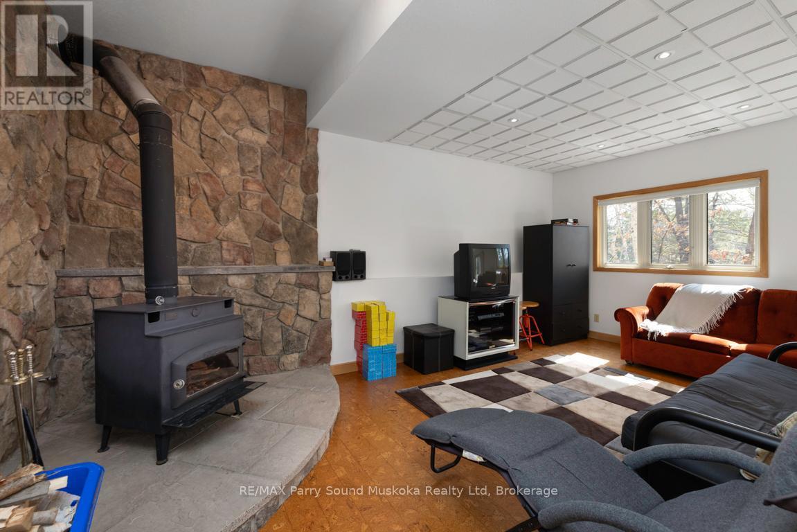 Lower level family room w woodstove - 38 Shebeshekong Estates Road S, Carling, ON - Indoor Photo Showing Living Room With Fireplace