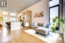 Living area with light wood finished floors and recessed lighting -