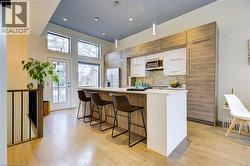 Kitchen featuring white cabinetry, tasteful backsplash, light wood-type flooring, pendant lighting, and recessed lighting -