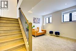 Living area with light carpet, stairs, and recessed lighting -