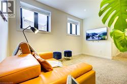 Carpeted living area featuring baseboards -