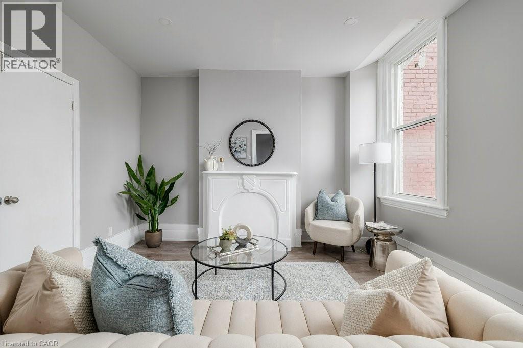 Living room with wood finished floors and baseboards - 125 Cathcart Street Unit# Lower, Hamilton, ON - Indoor Photo Showing Living Room With Fireplace