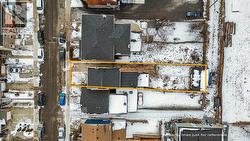 Snowy aerial view with property boundaries highlighted and a residential view -