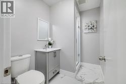 Full bath featuring vanity, light marble finish floors, and a stall shower -