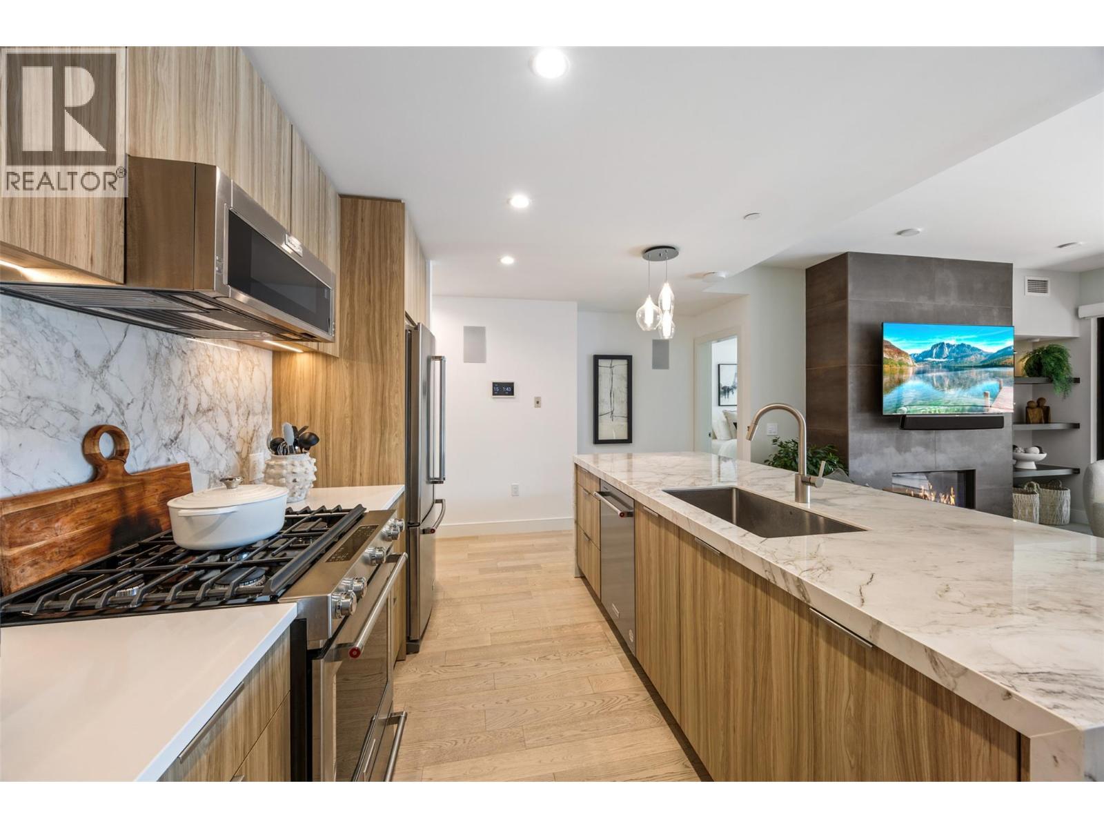 Beautiful kitchen with waterfall island countertop, stainless steel appliances - gas stove - 3000 Ariva Drive Unit# 3308, Kelowna, BC - Indoor Photo Showing Kitchen With Upgraded Kitchen
