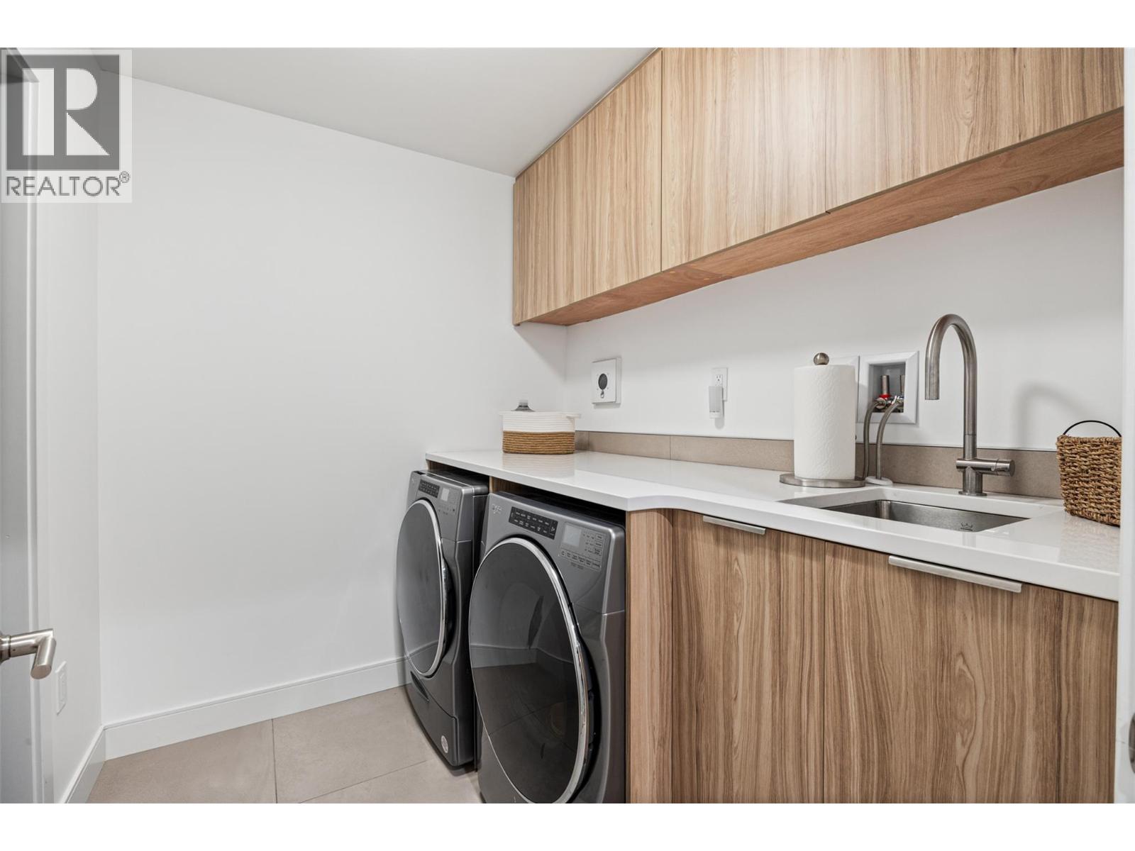 Functional laundry room with quartz counters, sink and cabinets - 3000 Ariva Drive Unit# 3308, Kelowna, BC - Indoor Photo Showing Laundry Room