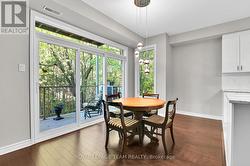 Dining area leads to balcony with views of trees -