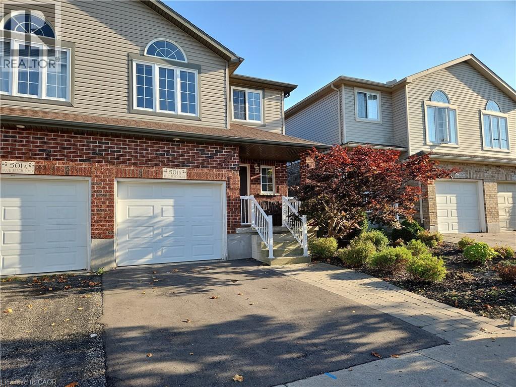 Traditional home with a garage, asphalt driveway, brick siding, and a porch - 501 Blue Beech Boulevard Unit# B, Waterloo, ON - Outdoor