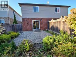 Rear view of house with a patio, brick siding, and a fenced backyard -