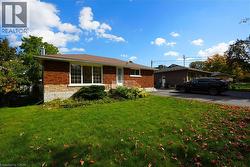 View of front of property featuring a front lawn and brick siding -