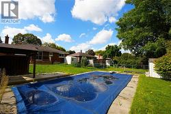 View of swimming pool with a patio, a storage shed, and a diving board -