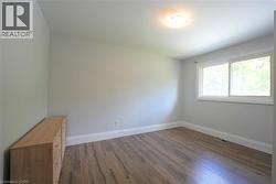 Empty room featuring dark wood-style floors and baseboards -