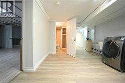 Washroom featuring washer / clothes dryer and light wood-style flooring -