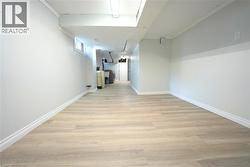 Corridor with light wood-style floors and crown molding -