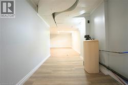 Hallway featuring light wood-type flooring and baseboards -