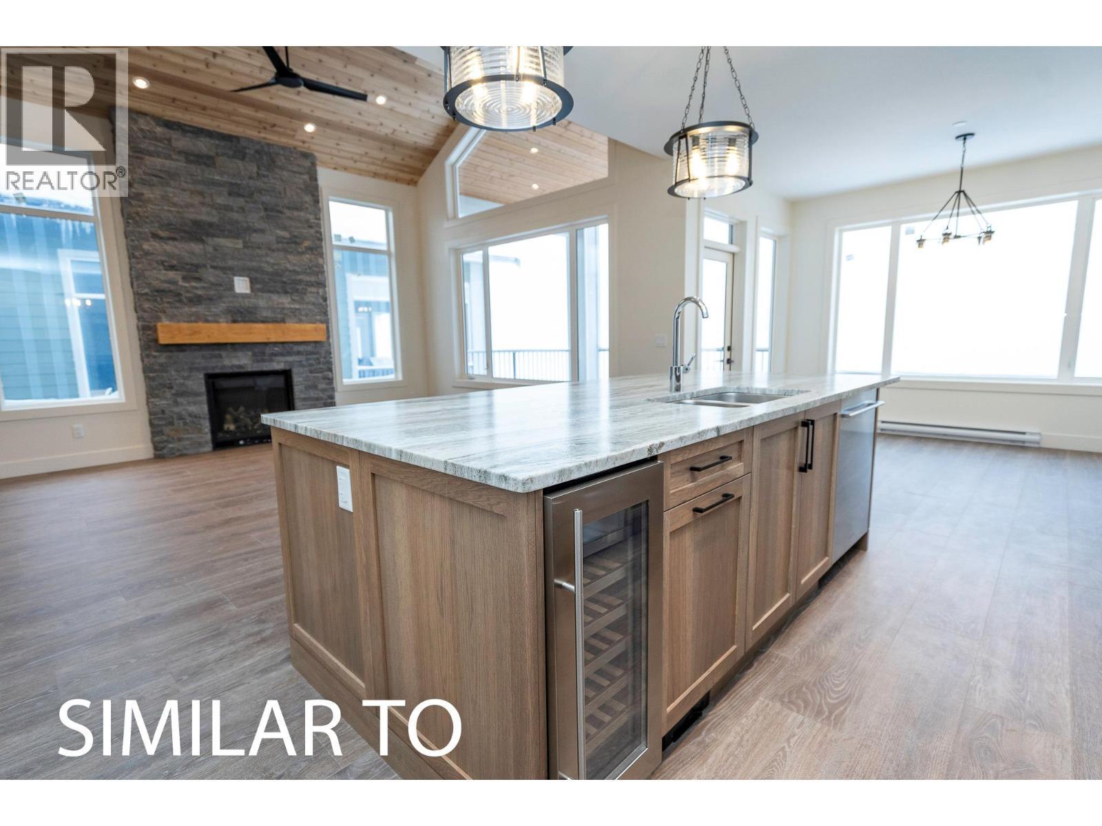 215B Grizzly Ridge Trail, Big White, BC - Indoor Photo Showing Kitchen With Fireplace