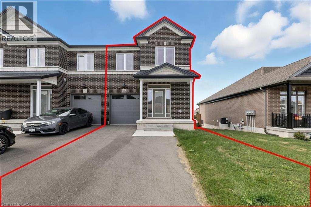 Traditional home with brick siding, a front yard, driveway, and an attached garage - 256 Keeso Lane, Listowel, ON - Outdoor