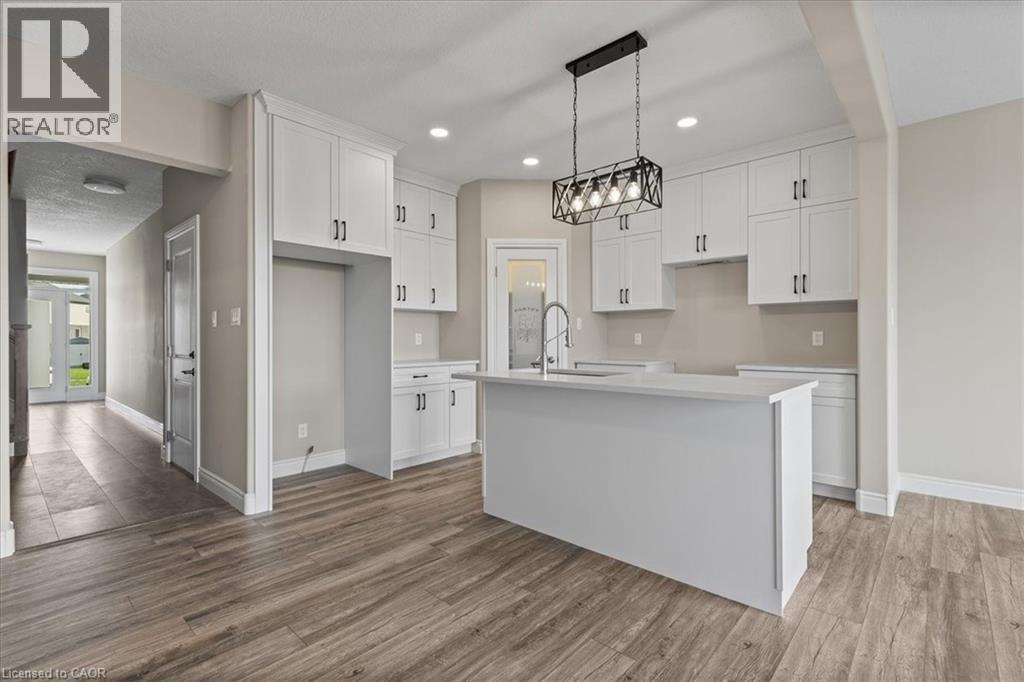 Kitchen with white cabinetry, an island with sink, light wood-style floors, decorative light fixtures, and recessed lighting - 256 Keeso Lane, Listowel, ON - Indoor Photo Showing Kitchen