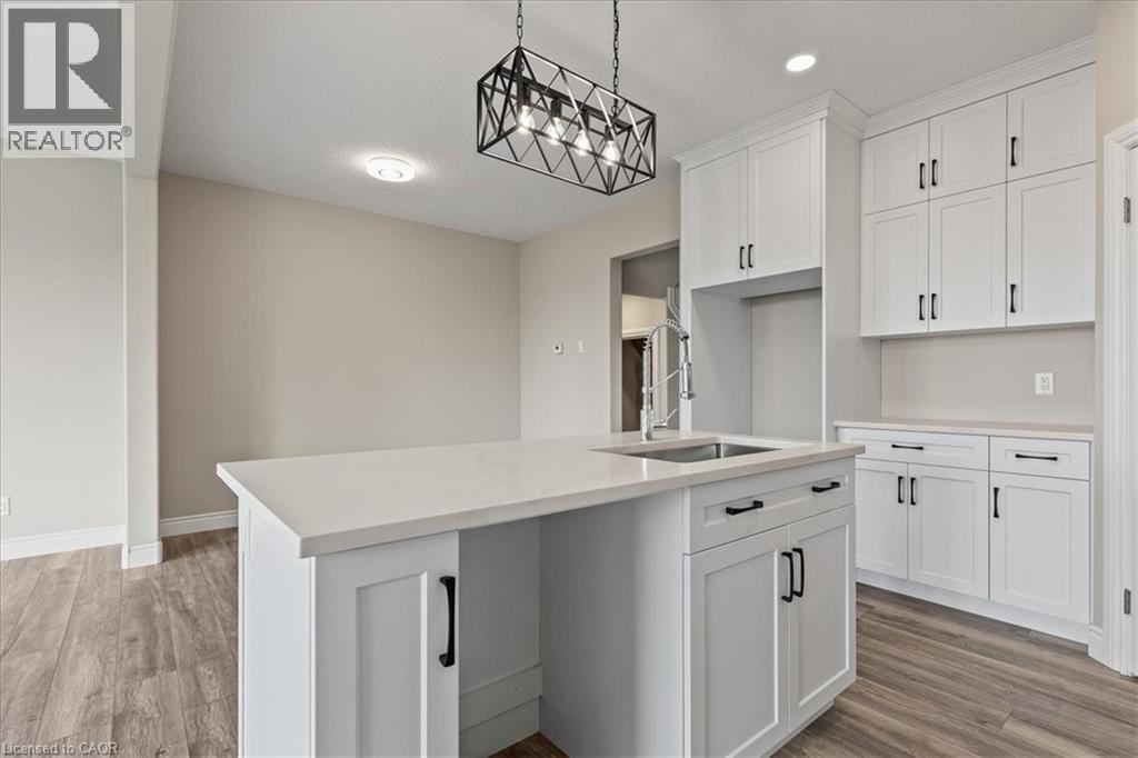 Kitchen with hanging light fixtures, a kitchen island with sink, light wood-style floors, white cabinets, and recessed lighting - 256 Keeso Lane, Listowel, ON - Indoor Photo Showing Kitchen