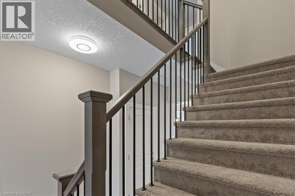 Staircase featuring a textured ceiling and carpet floors - 256 Keeso Lane, Listowel, ON - Indoor Photo Showing Other Room