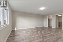 Unfurnished bedroom with a walk in closet and light wood-style flooring -